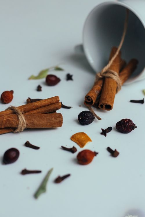 Free Aesthetic arrangement of cinnamon sticks, dried fruits, and cloves for culinary inspiration. Stock Photo