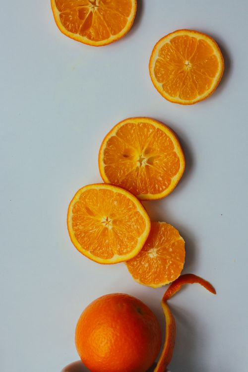 Free Close-up of fresh orange slices arranged on a minimalist white background. Stock Photo