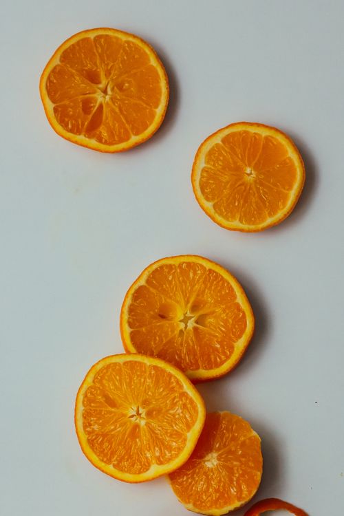 Free Fresh orange slices arranged artfully on a clean white backdrop for vibrant presentation. Stock Photo