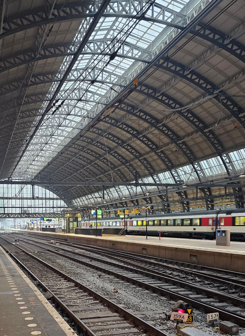 Interieur van Amsterdam Centraal Station met architectonisch ontwerp en lege sporen.