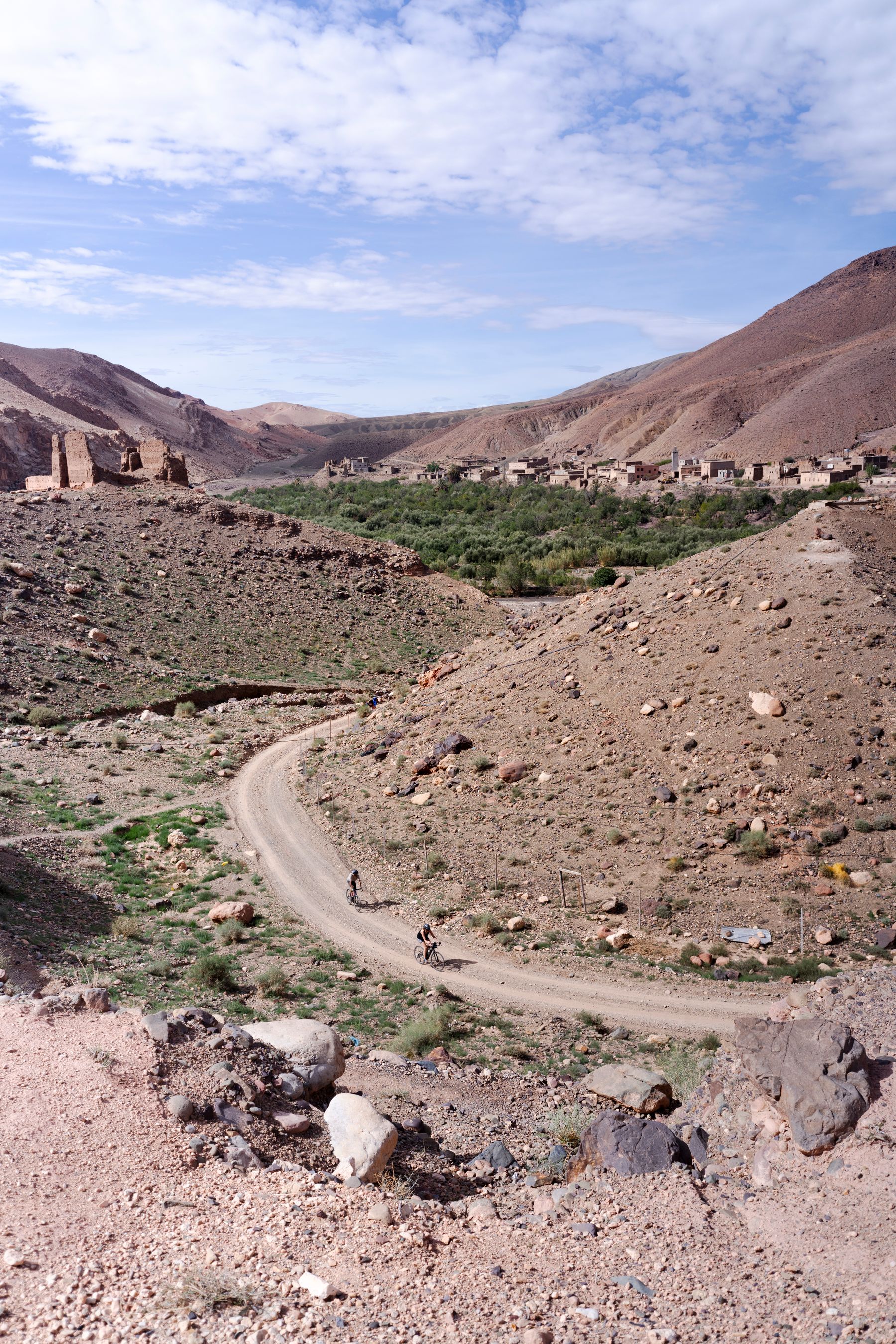 Cyclist riding through rugged Moroccan mountain and desert terrain