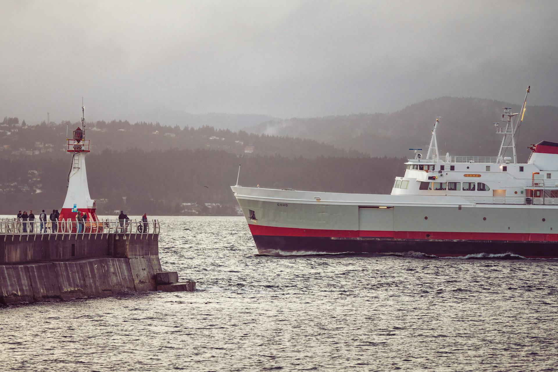 A ferry approaches a breakwater with a lighthouse in Victoria, British Columbia.