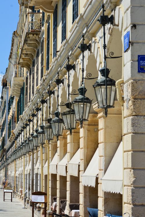 Free Historic architectural arcades with hanging lanterns in Corfu, Greece, under clear blue skies. Stock Photo