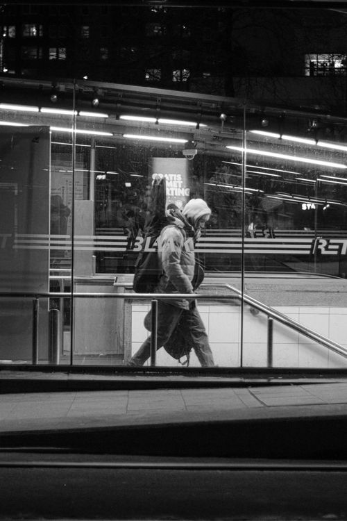 Free Black and white image of a person entering a subway station at night in an urban setting. Stock Photo