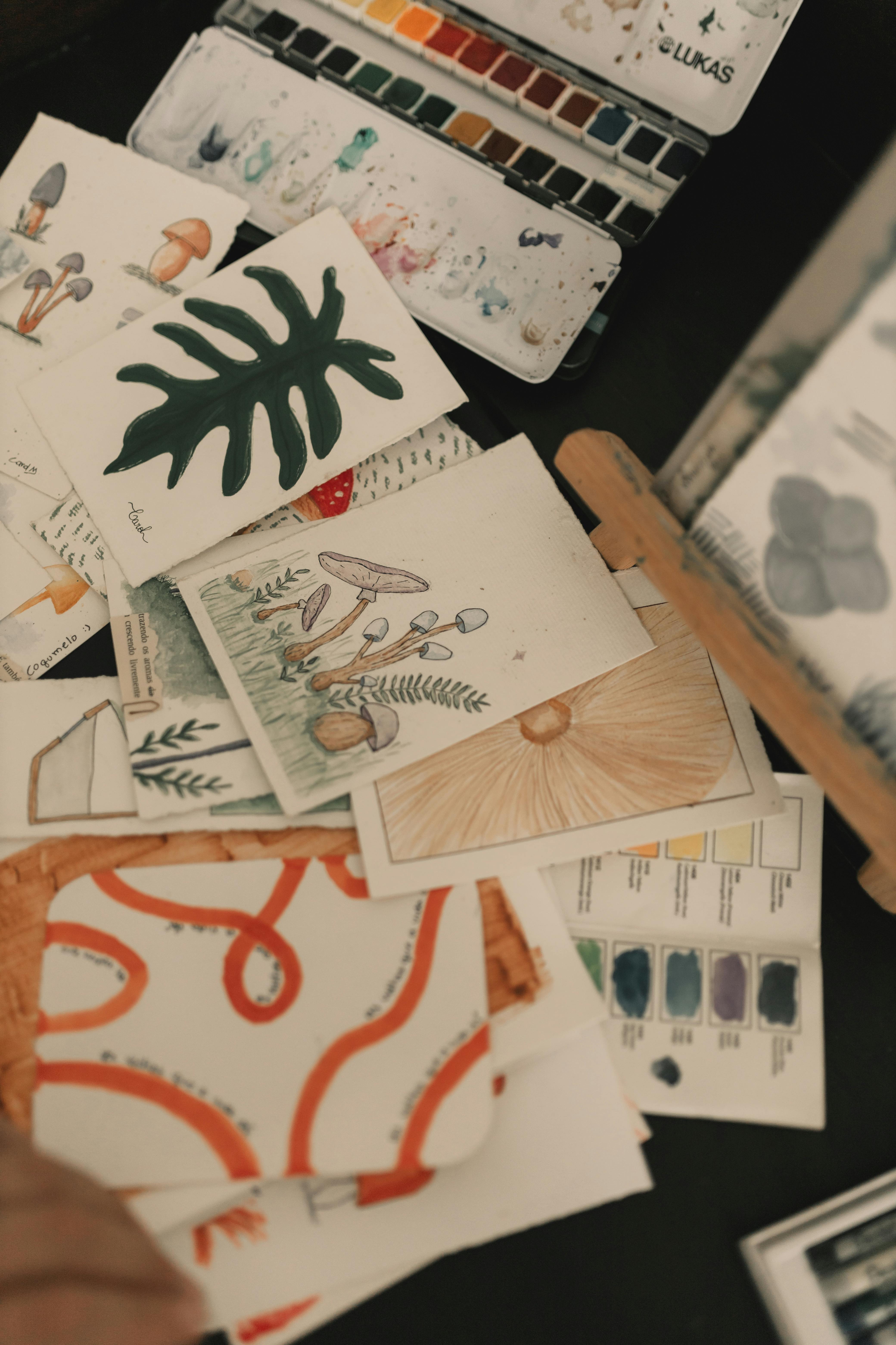 Collection of watercolor paintings and art supplies showcasing nature themes and vibrant colors.