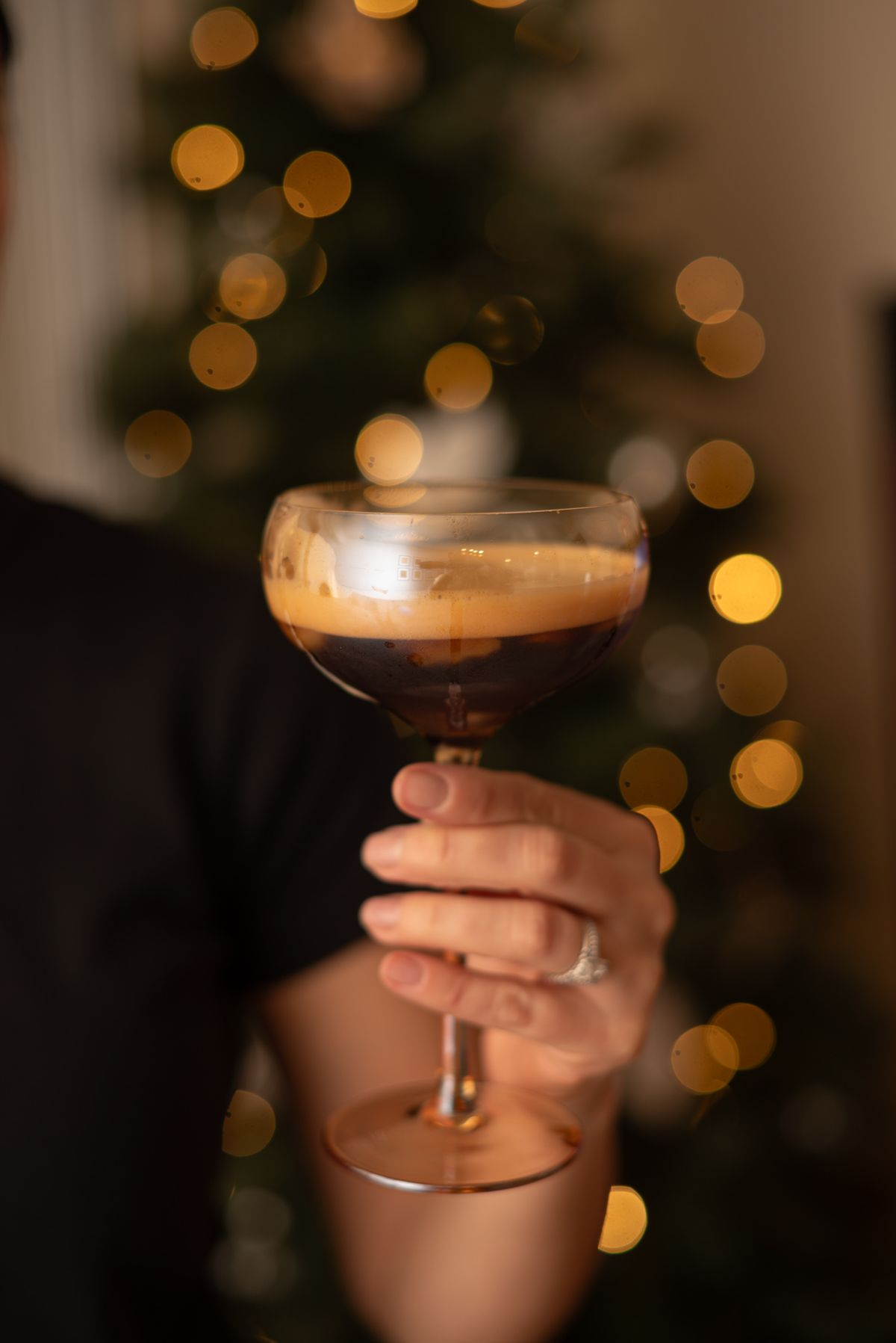 Creamy espresso style dessert cocktail held up at a party