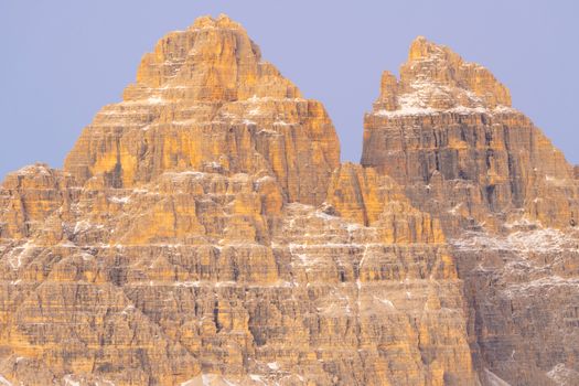 Stunning view of towering rocky mountain peaks bathed in warm golden light, showcasing nature's beauty.