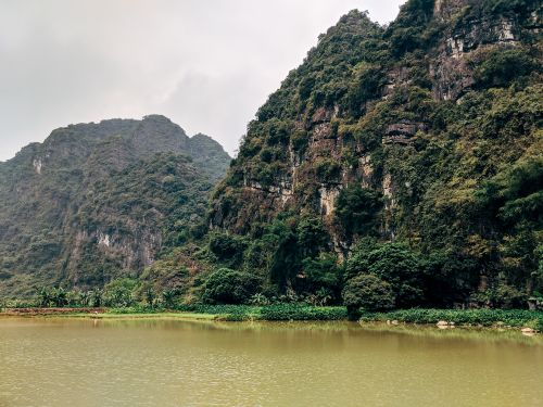 Free Stunning view of Vietnam's lush limestone mountains reflecting in a serene lake. Stock Photo