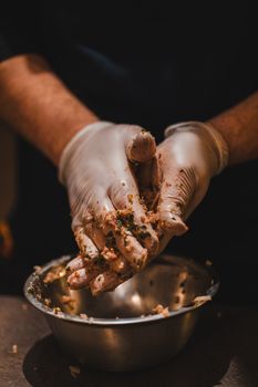 Chef preparing meatballs with gloves for safe and hygienic food handling.