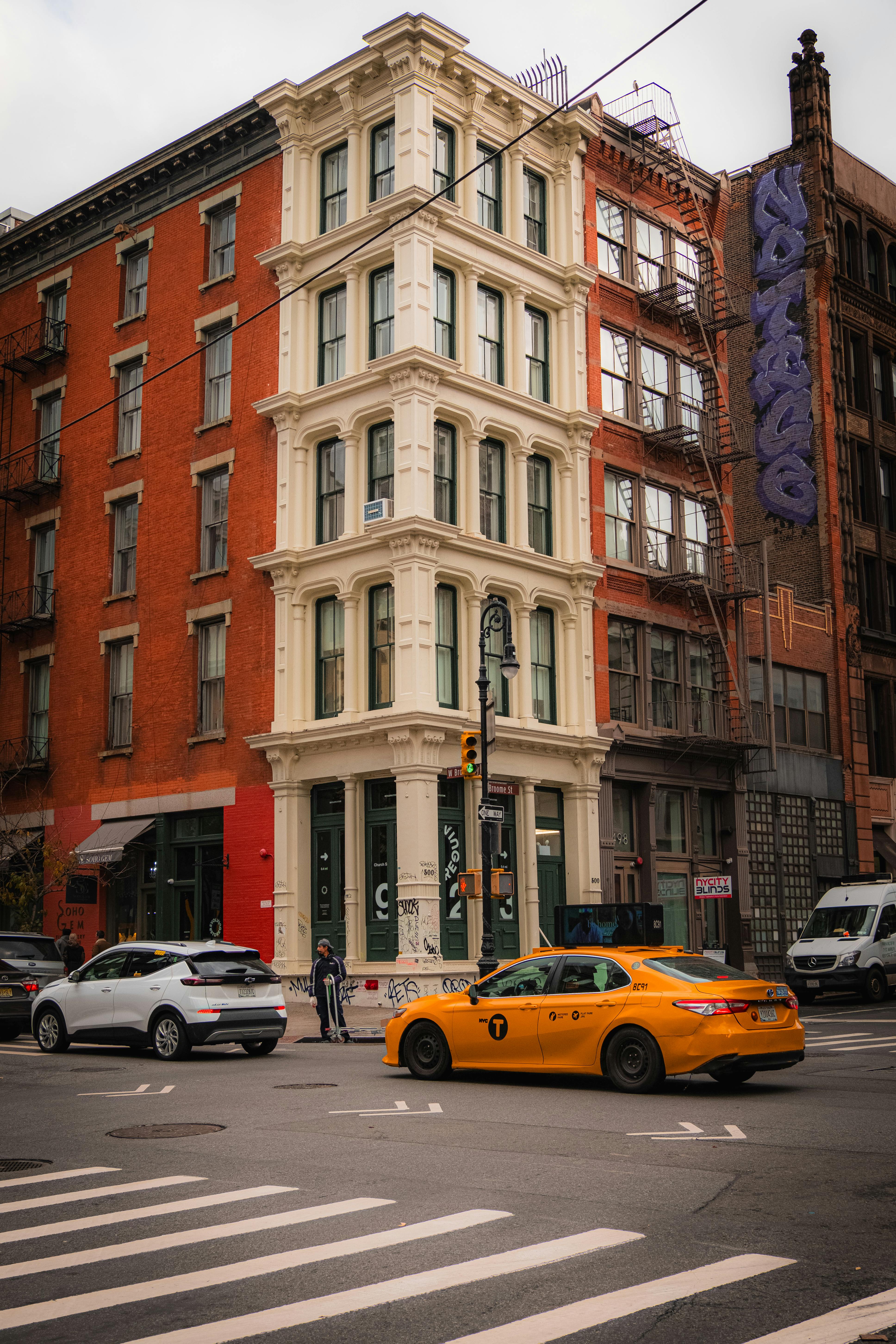 A vibrant city street with historic architecture and iconic yellow taxi.
