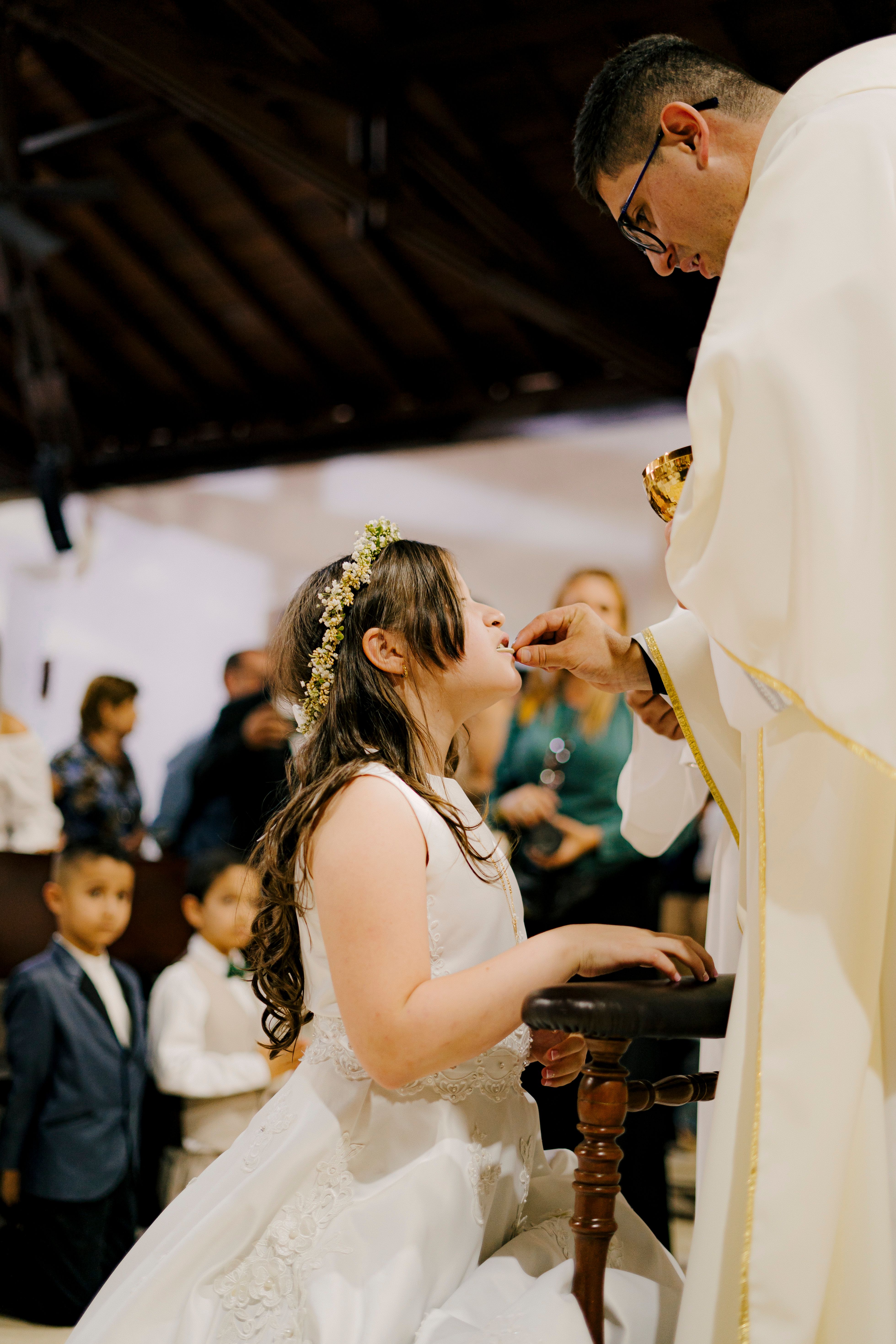 Young girl receiving communion from a priest during Mass