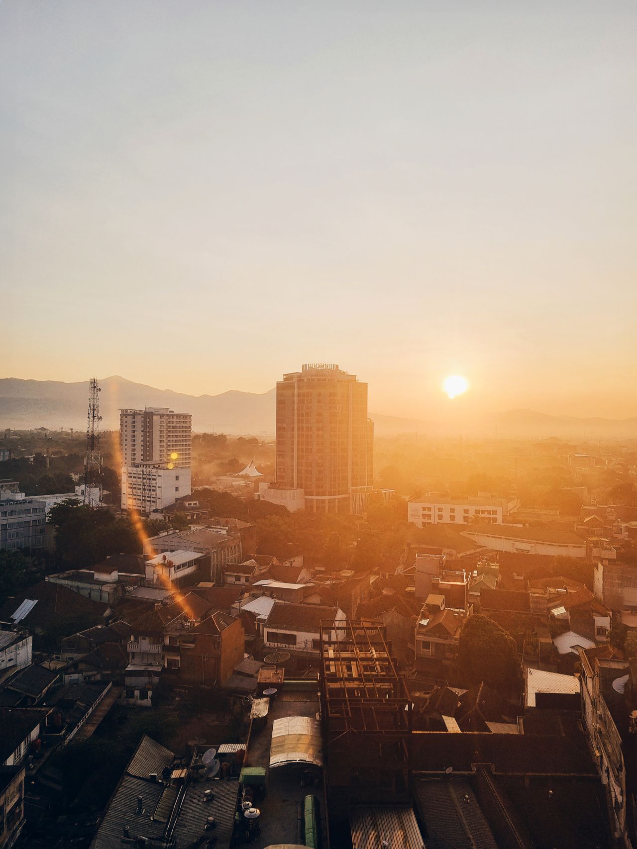 Stunning sunrise view over Bandung city with mountain silhouettes and urban skyline