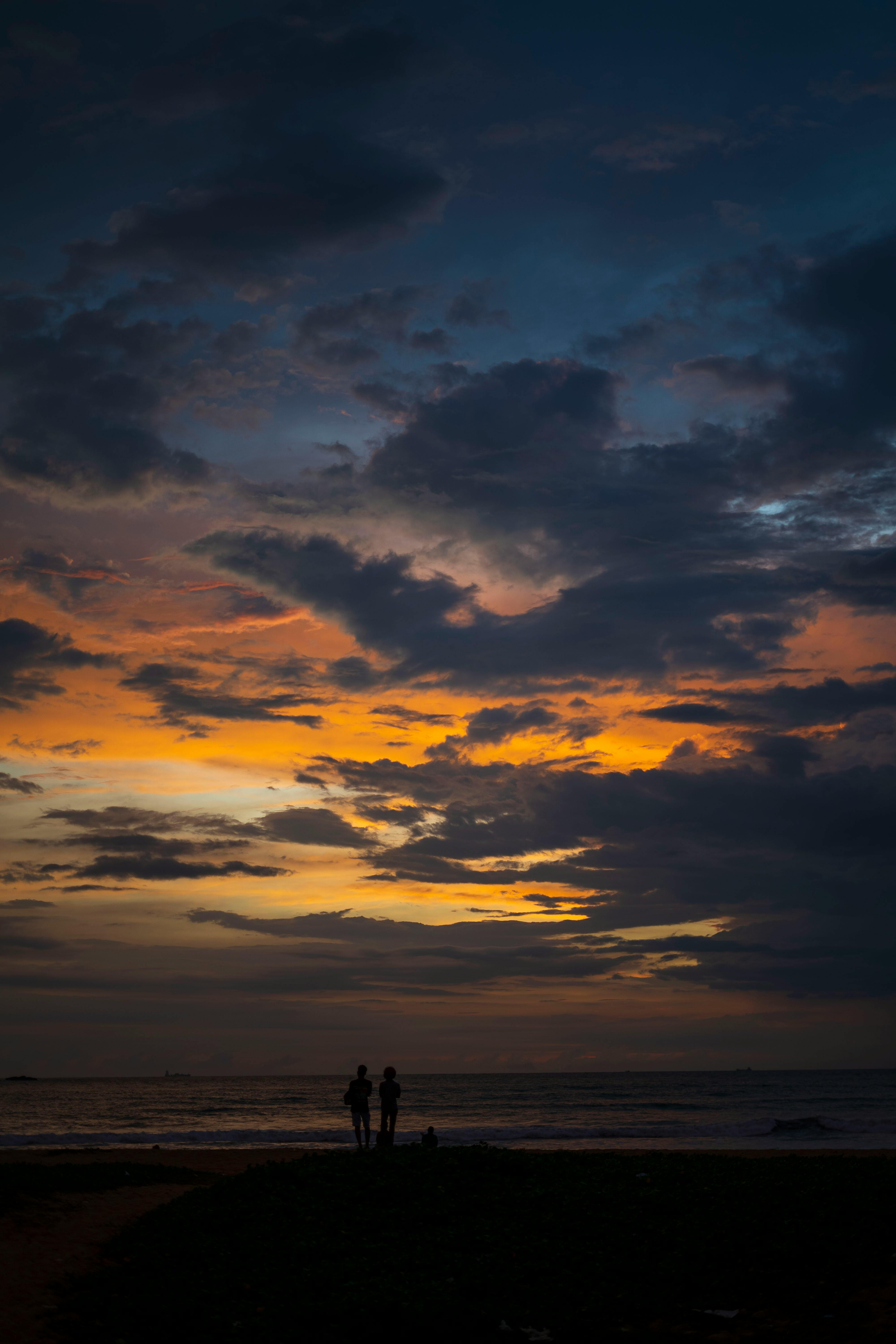 無料 スリランカ西部州の海に映える鮮やかな夕焼け空を背景にした美しいシルエット。 写真素材