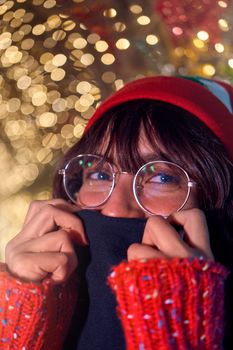 Close-up of a woman in festive attire with glowing Christmas lights in Guanajuato, Mexico.