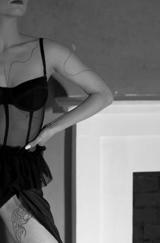 Black and white close-up of a woman in elegant lingerie with a tattoo.