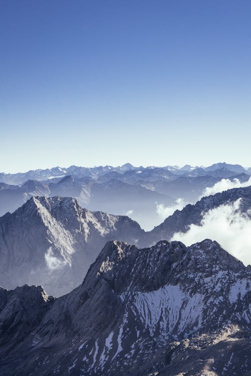Kostenlos Luftaufnahme Des Mit Schnee Bedeckten Berges Unter Blauem Und Weißem Himmel Stock-Foto