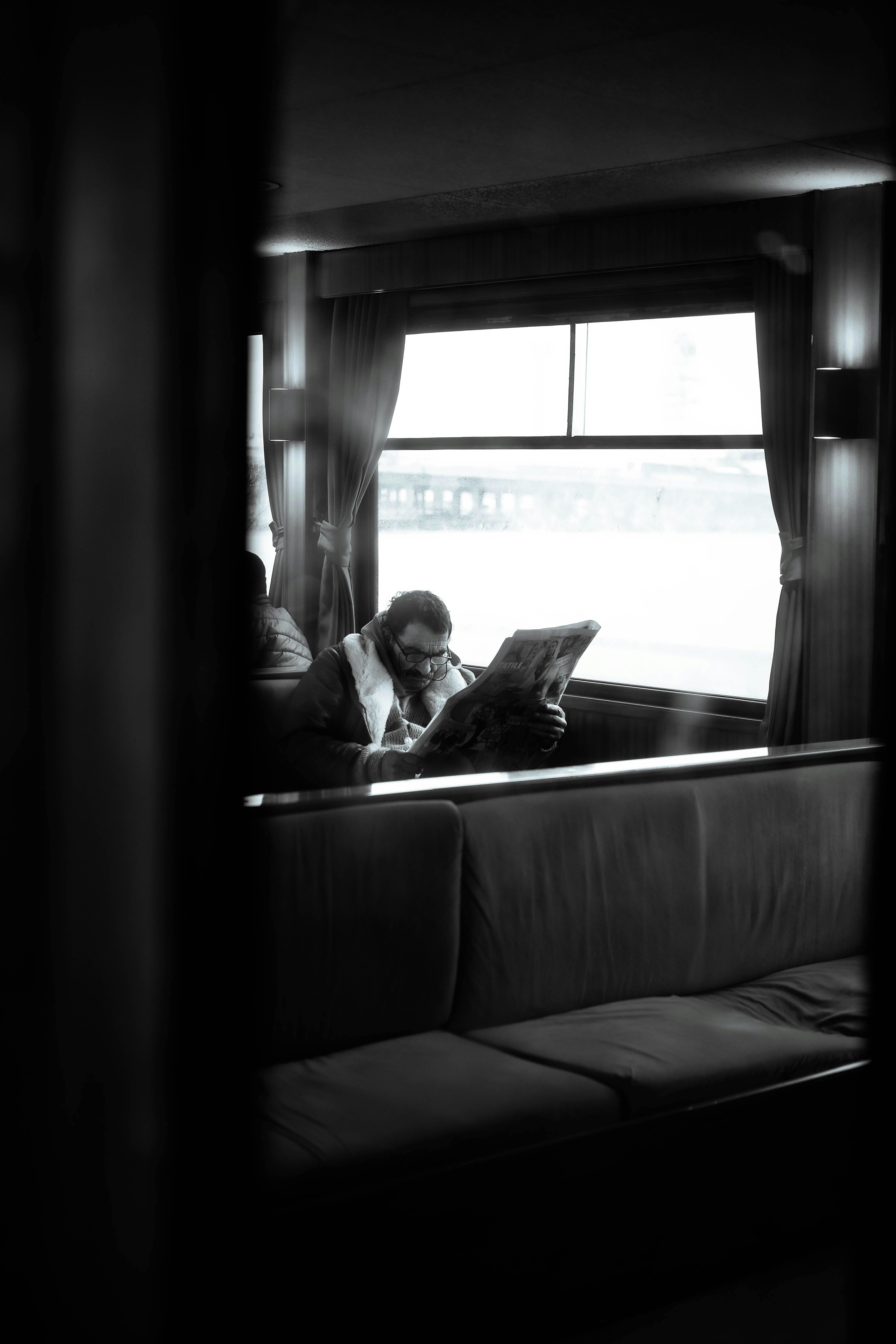 무료 이스탄불의 페리에서 신문을 읽는 남자가 흑백으로 고전적인 거리 사진 스타일을 포착했습니다. 스톡 사진