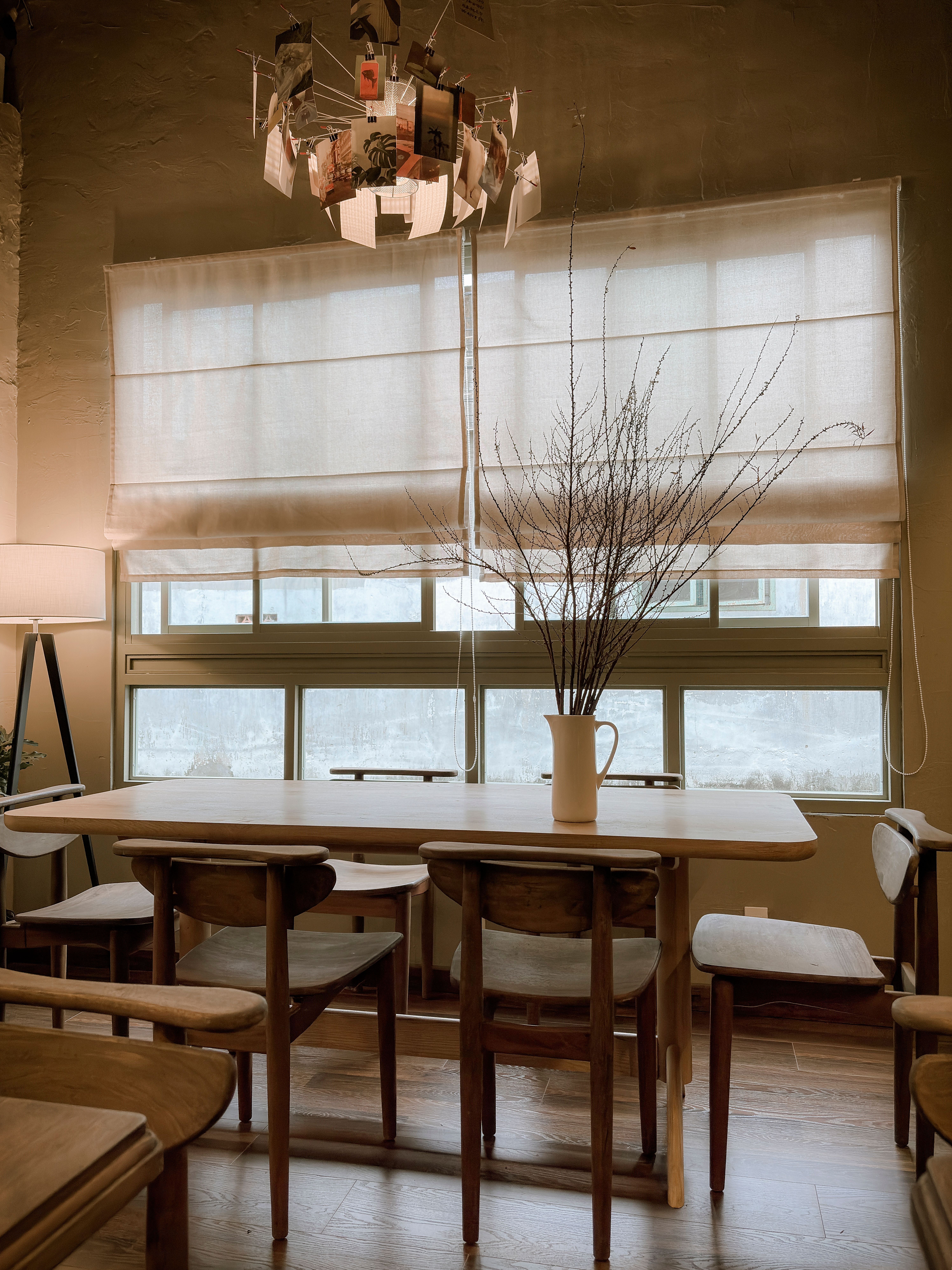 A serene dining area with wooden furniture, minimalist decor, and natural light streaming in.