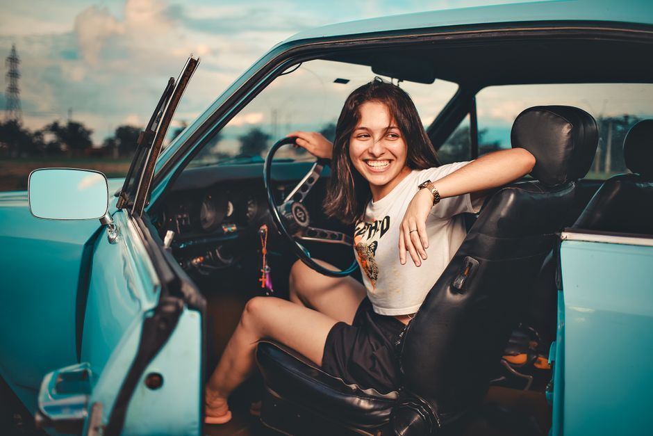 happy woman smiling in car — save on car insurance with discounts