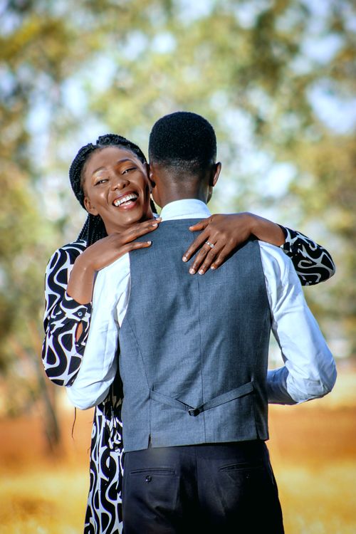 Free A smiling couple embracing in an outdoor setting, showcasing love and happiness. Stock Photo