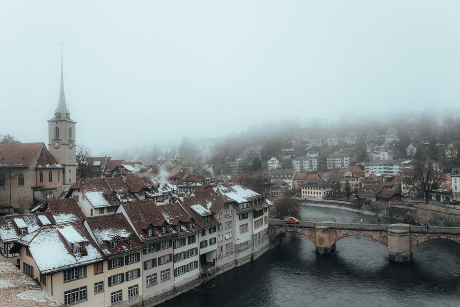 A foggy winter day showcasing the iconic architecture and bridge in Bern, Switzerland.