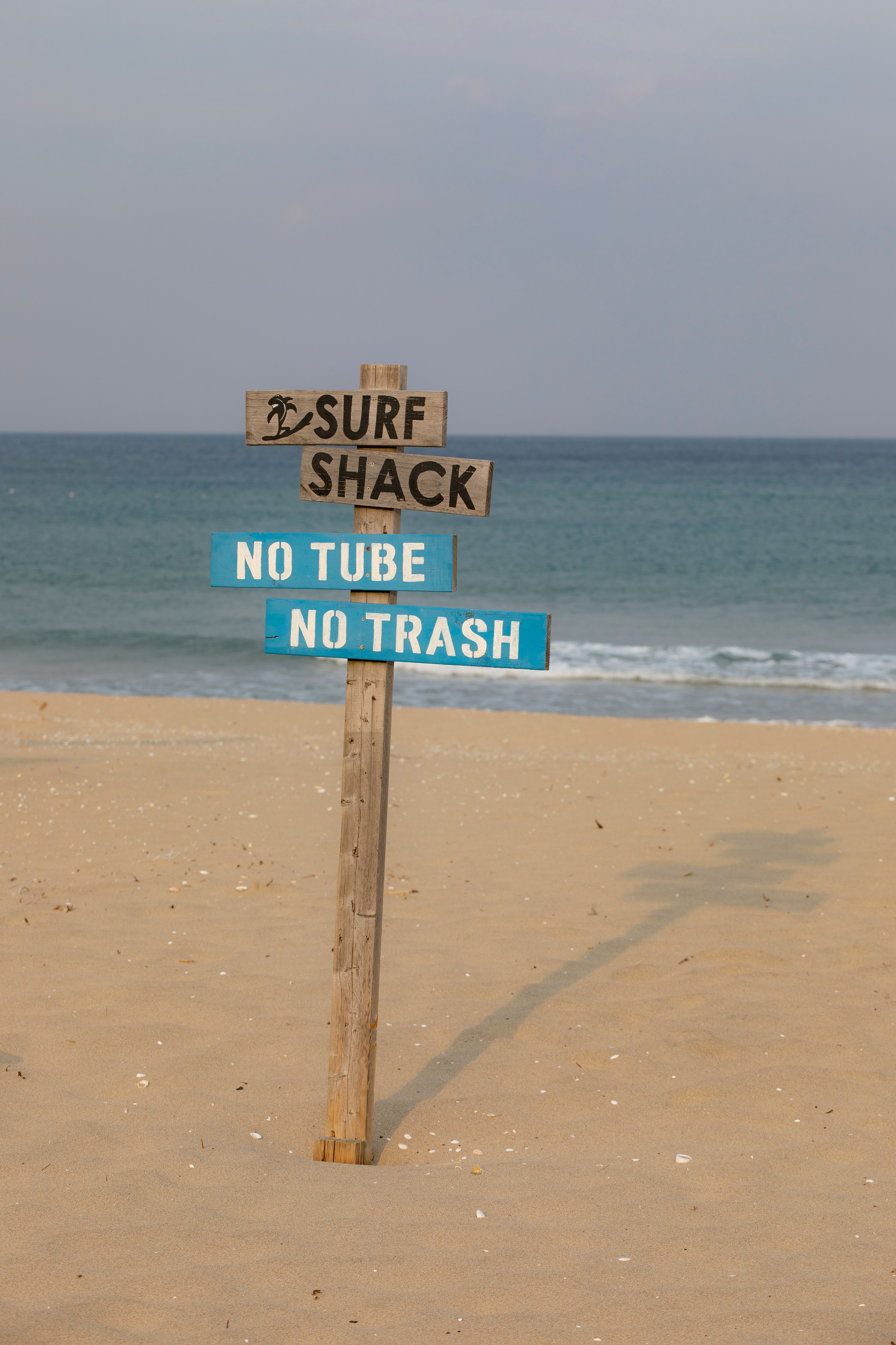 Beach Sign with Surf Shack Warning and Ocean View · Free Stock Photo
