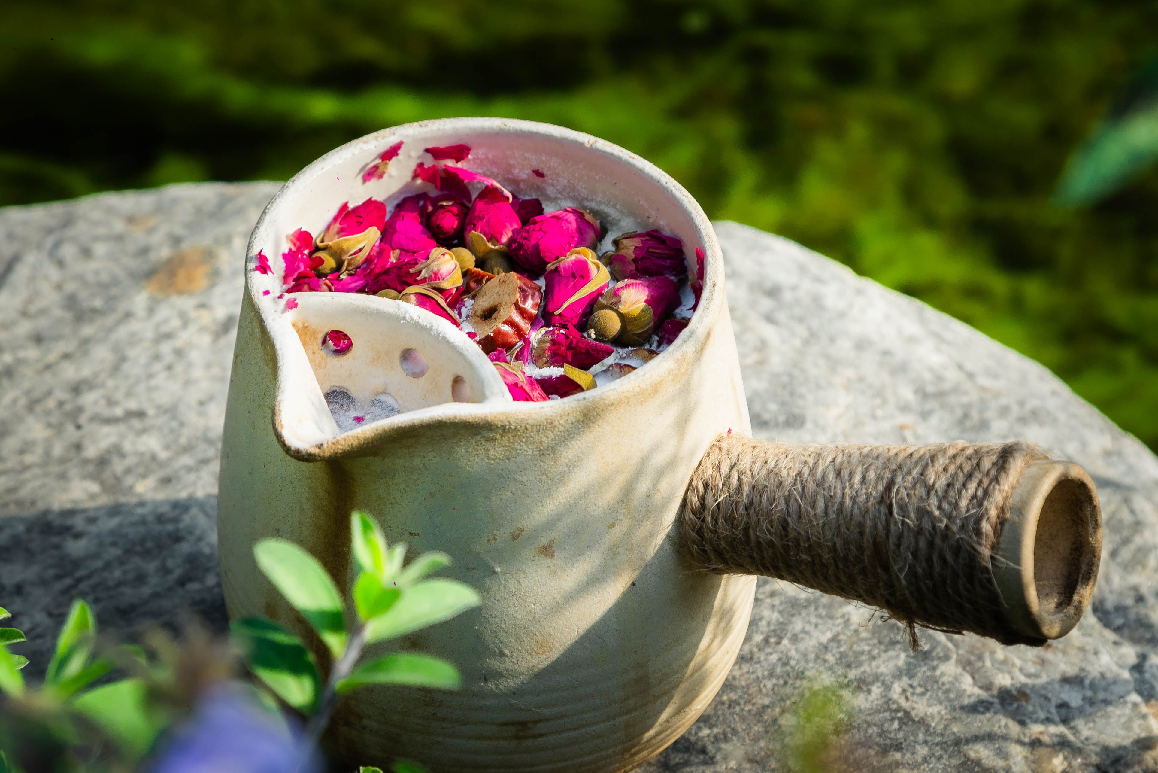 Ceramic Jug with Rose Petals on Stone Surface Outdoors · Free Stock Photo