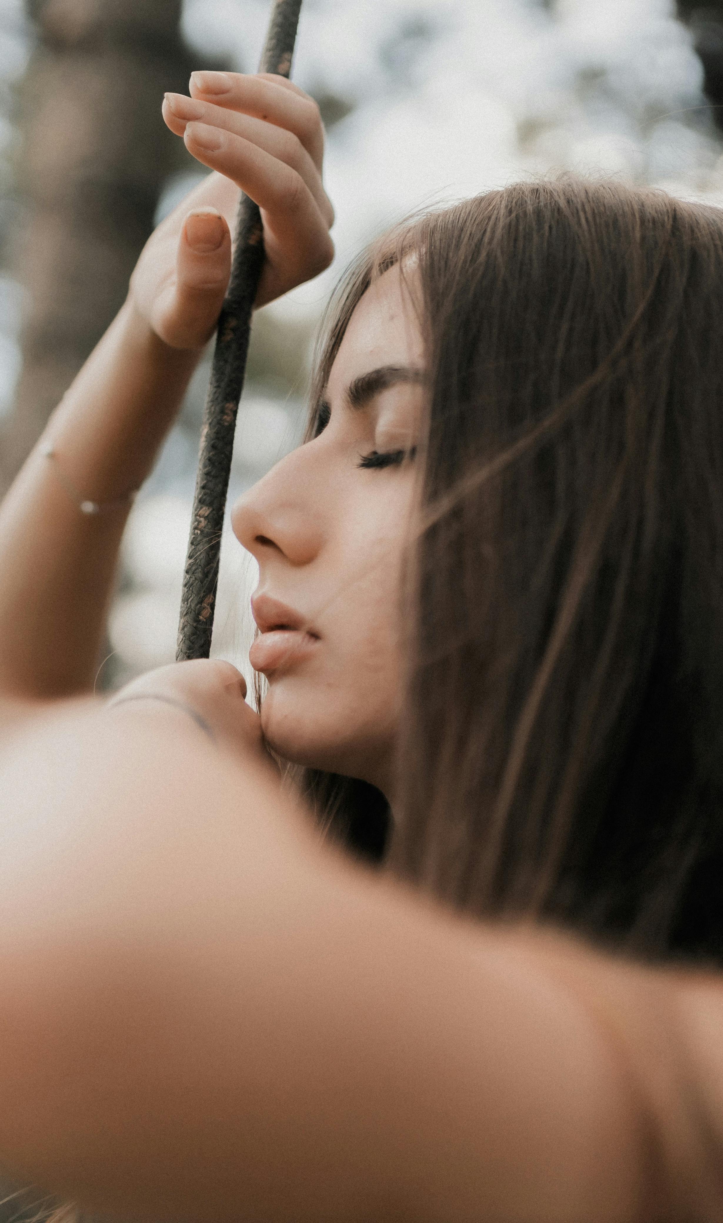 Serene woman with eyes closed in deep relaxation, soft focus portrait, peaceful trance-like expression bathed in gentle light