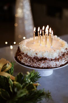 A delicious frosted birthday cake with lit candles, perfect for celebrations.