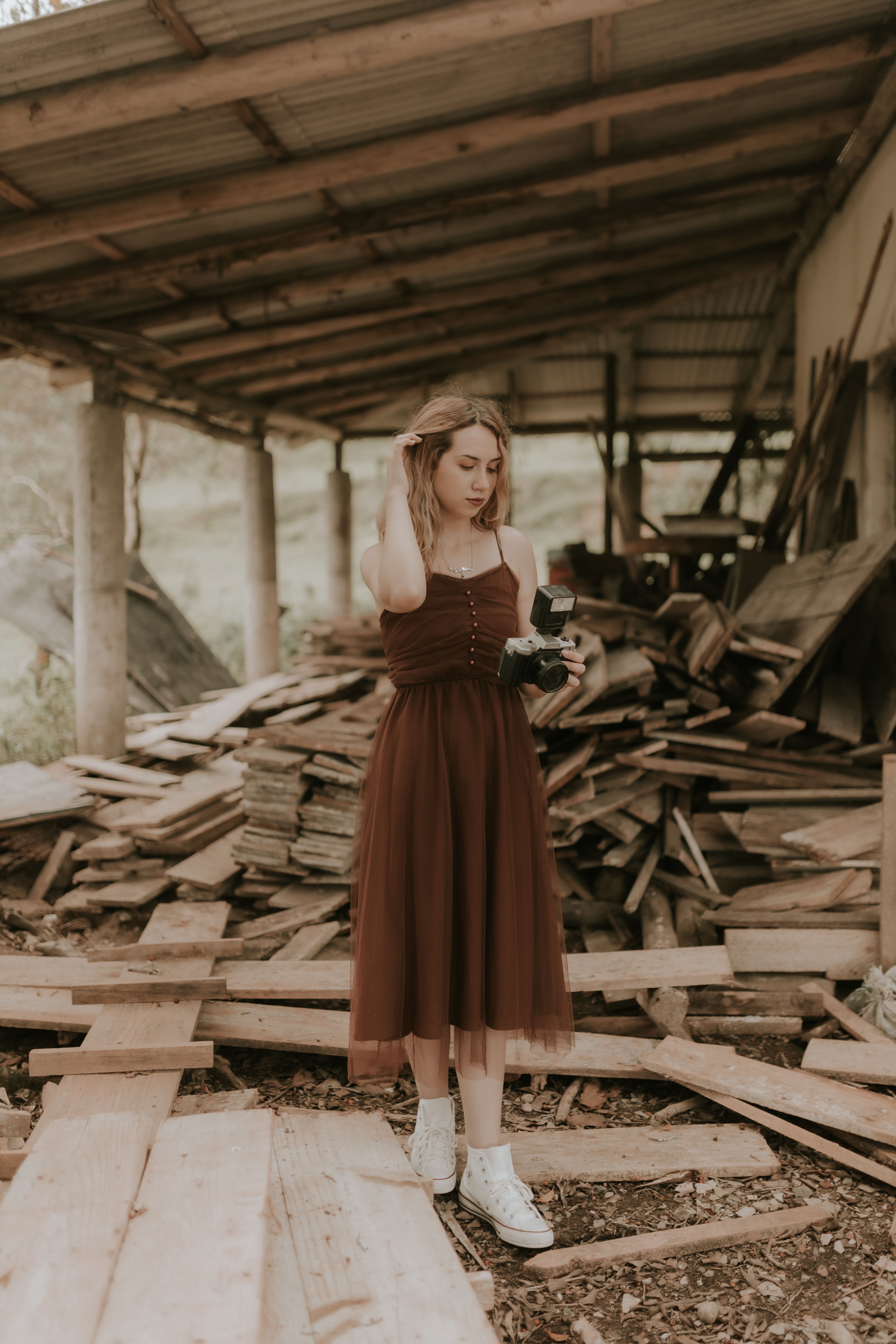 Woman in Brown Dress Standing in Rustic Shed  Free Stock Photo