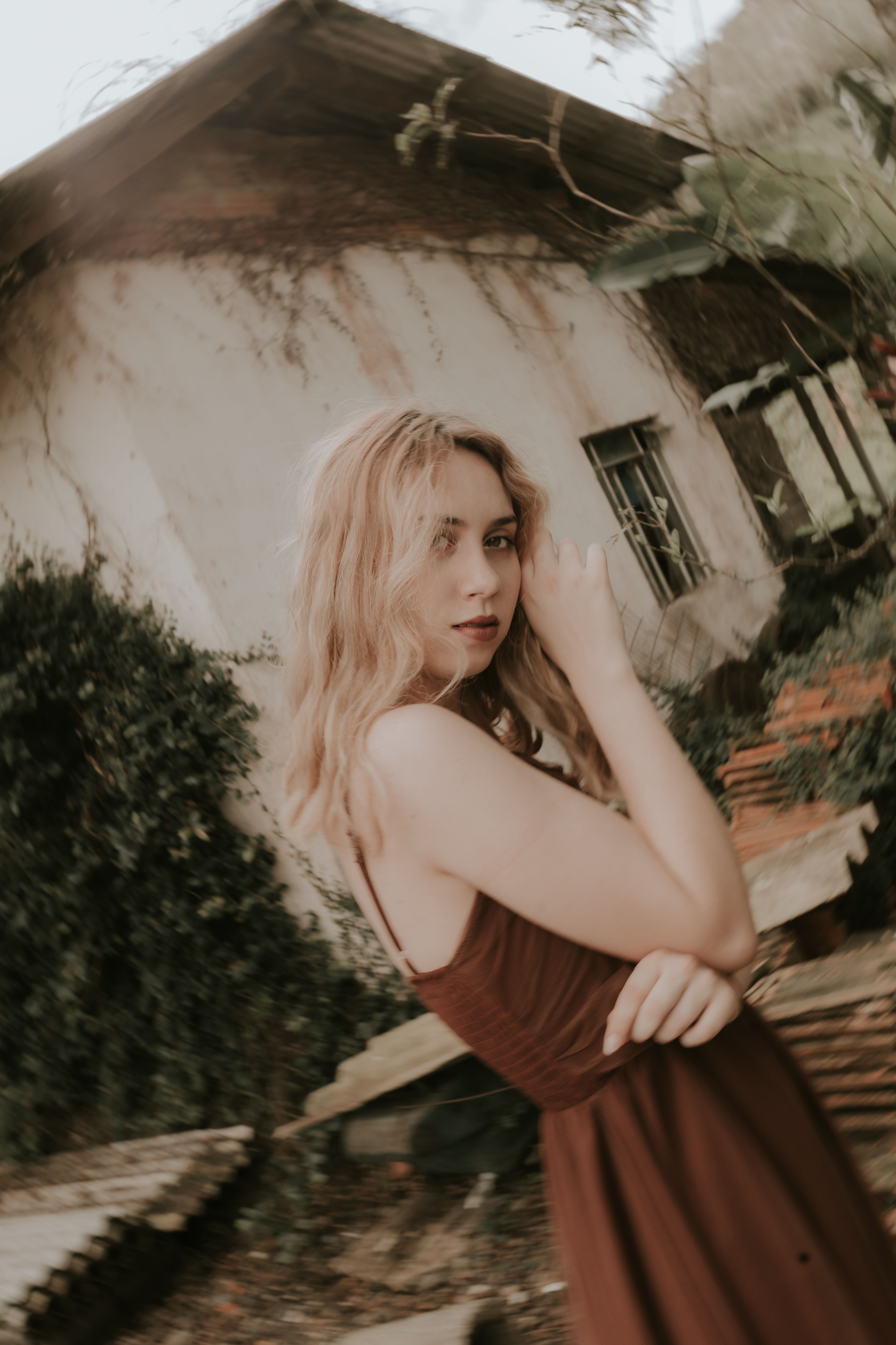 Artistic portrait of a woman with vintage style in an outdoor setting.