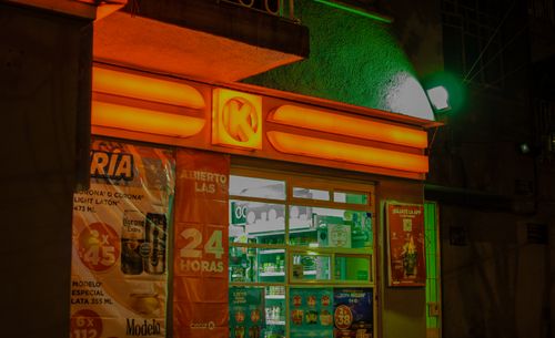 Free A brightly illuminated convenience store with neon lights at night, showcasing vibrant colors and signage. Stock Photo