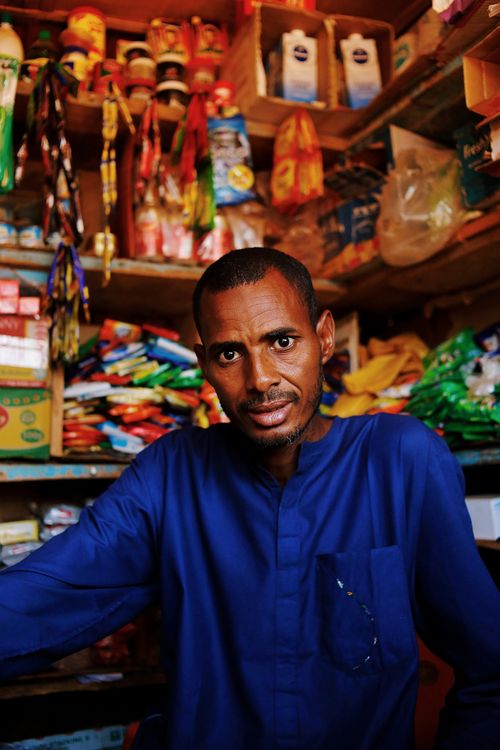 Free Vibrant portrait of a shopkeeper amid colorful merchandise in Abuja, Nigeria. Stock Photo