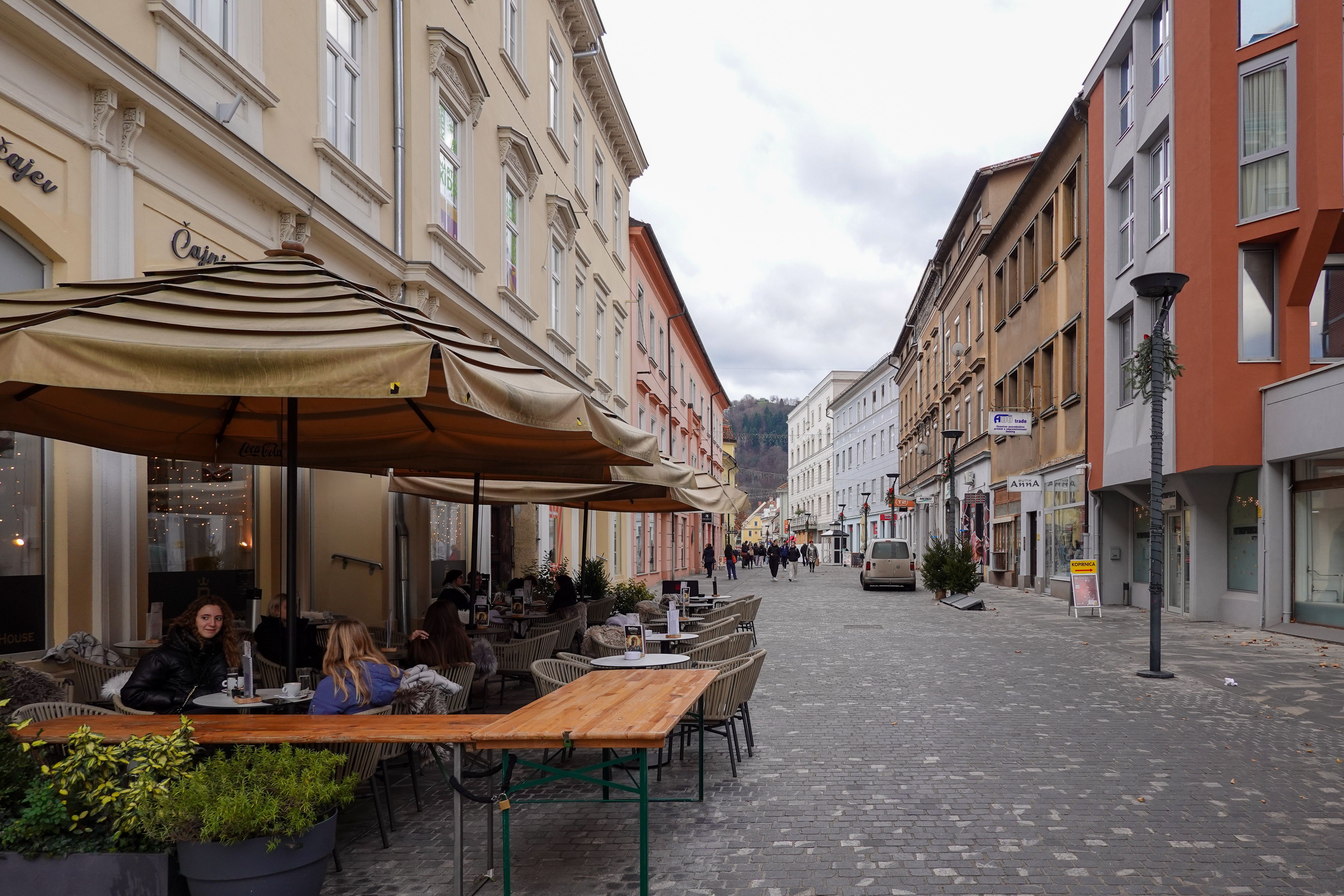 A quiet cobblestone street in a lesser-known European city with outdoor cafes and no crowds
