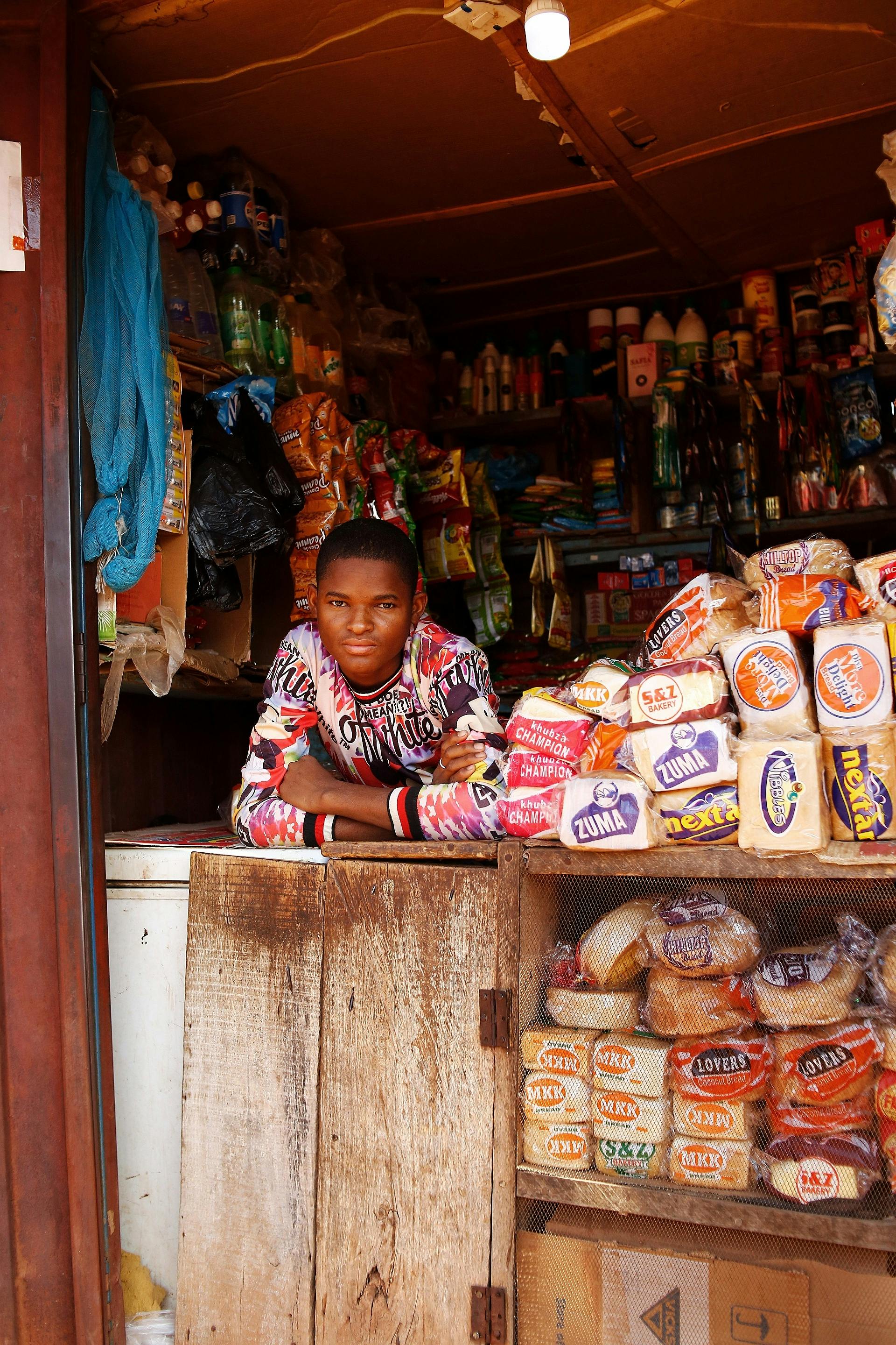 local shopkeeper posing in abuja market