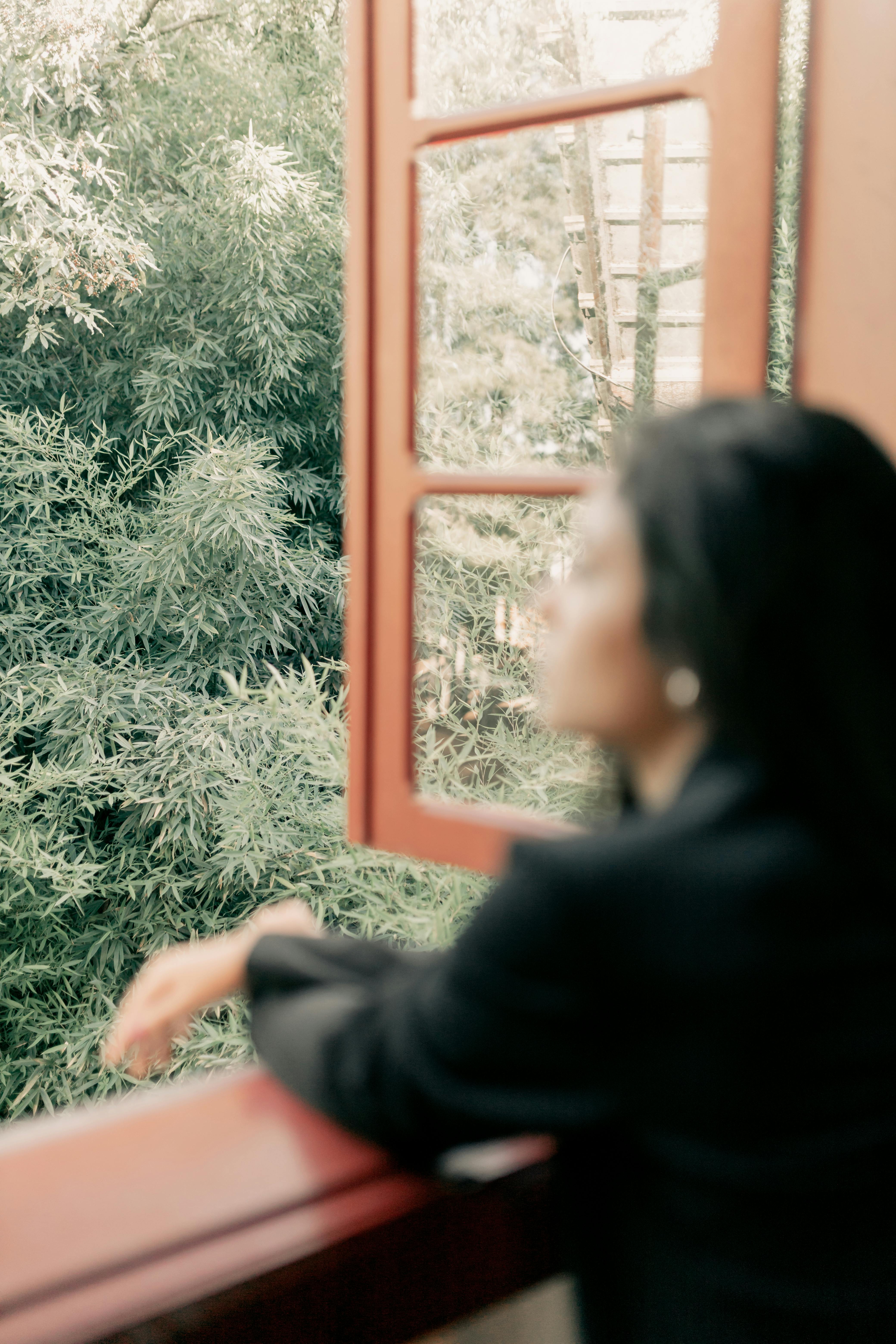Woman Gazing Out of a Window at Nature · Free Stock Photo