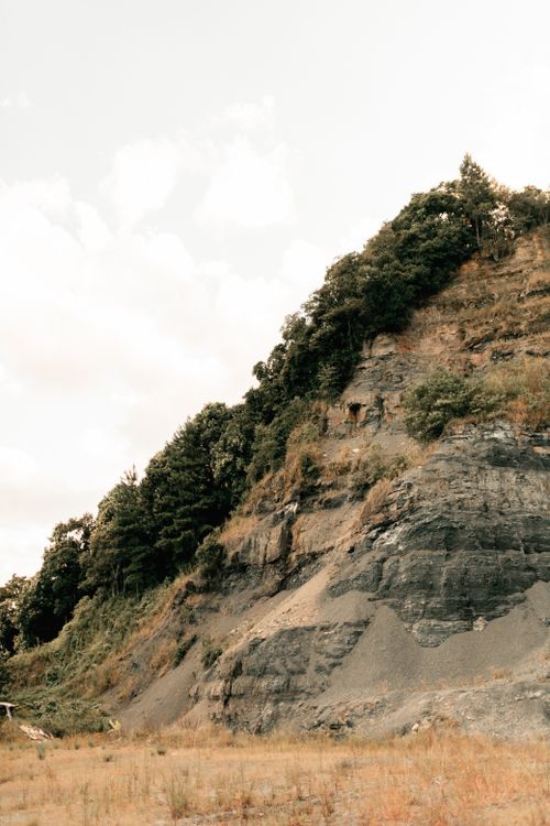 Free Steep rocky cliff under a soft sky, blending nature and geology. Stock Photo