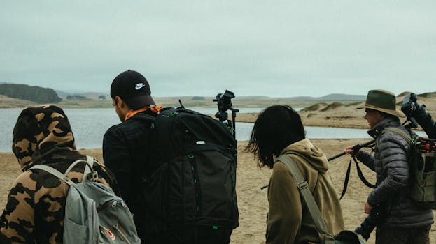 一群摄影师带着装备，沿着海岸线冒险，捕捉沿途的风景