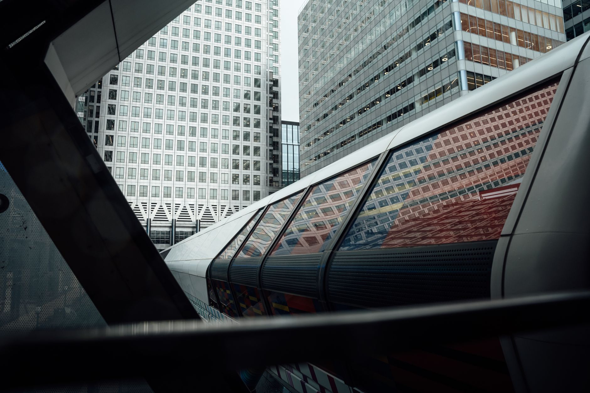 Sleek urban landscape of Canary Wharf with futuristic architecture and reflections.