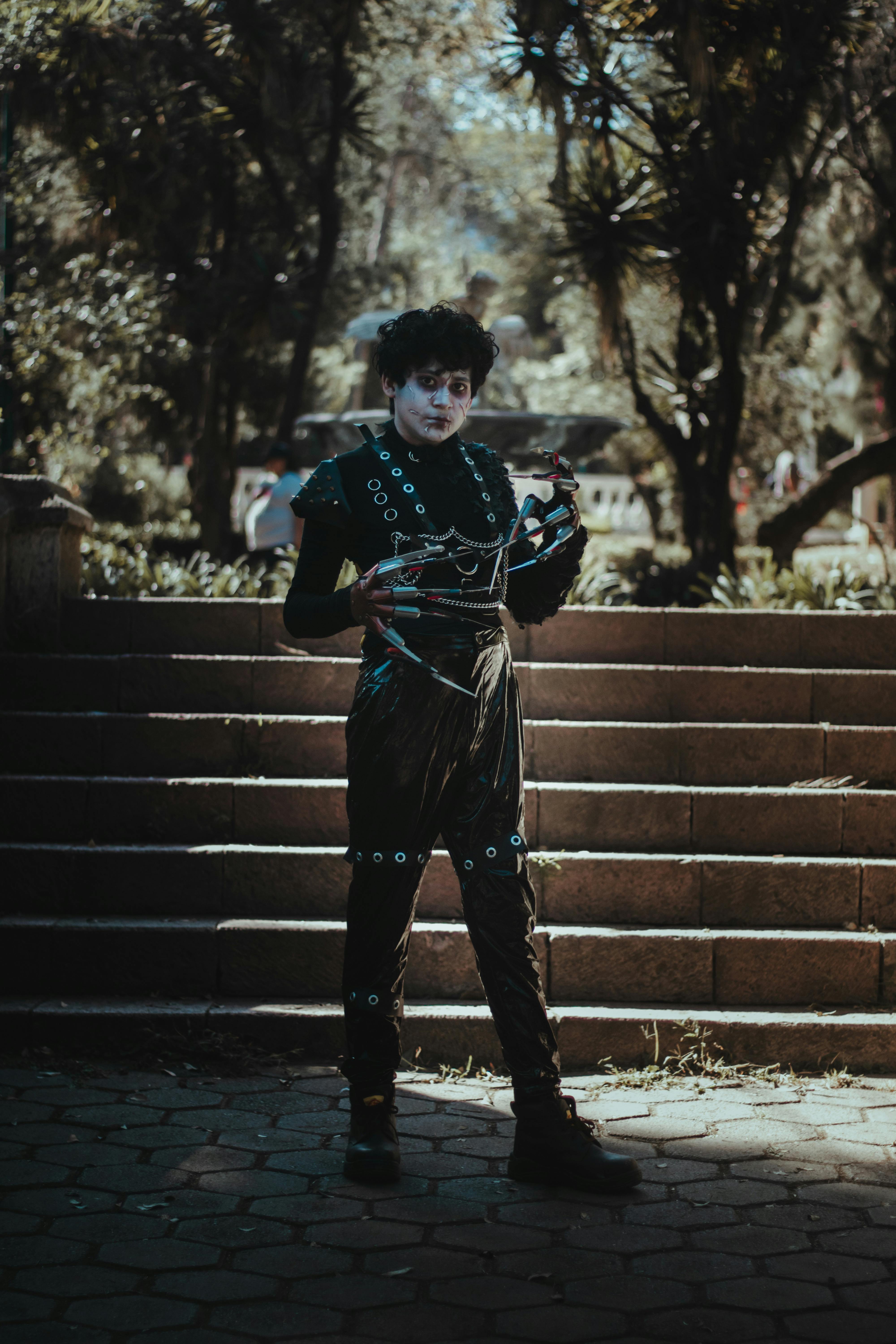 Ücretsiz Tiyatro karakteri, parkta, benekli güneş ışığı altında kostümüyle poz veriyor. Stok Fotoğraflar