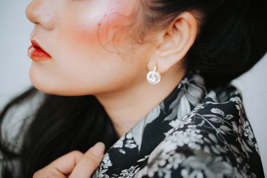 Close-up portrait of a woman showcasing elegant earrings and makeup