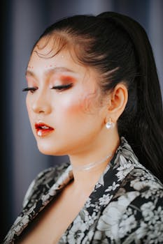 Close-up portrait of a woman with striking artistic makeup and pearl earring.