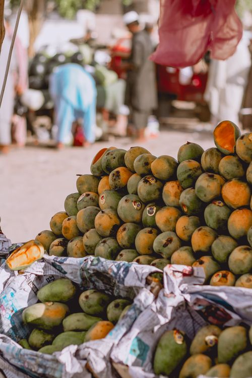 Free Fresh, ripe mangoes on display at a bustling Southeast Asian market, inviting healthy refreshing choices. Stock Photo