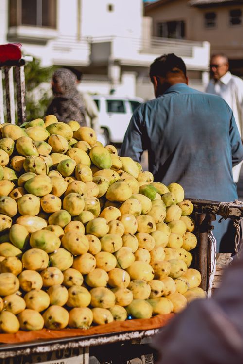 Free Lush mangoes piled high in an outdoor stall, typical Asian street market scene. Stock Photo