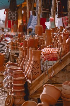 Colorful display of handcrafted terracotta pots at a bustling outdoor market.