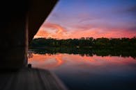 宁静的森林湖上，倒映着迷人的日落和充满活力的天空