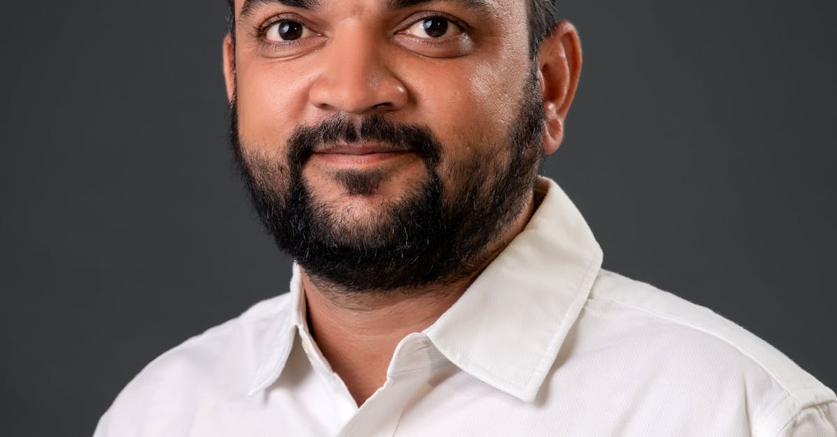 Professional portrait of a man in a white shirt against a gray background.
