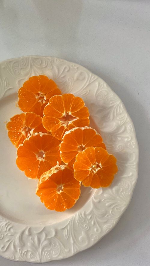 Free Bright orange slices arranged on an ornate white plate, perfect for healthy eating concepts. Stock Photo