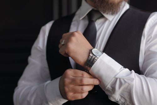 Free Close-up of a groom adjusting his cufflinks, showcasing his stylish watch and ring. Stock Photo