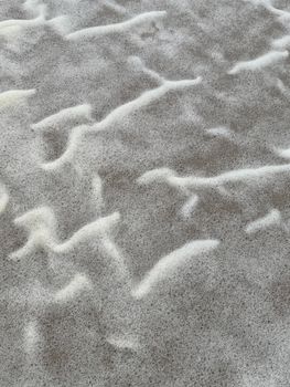 Close-up of abstract patterns in beach foam creating a soothing texture.